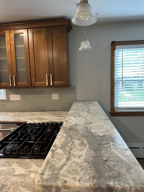 15 Evans, Somerset, MA 02726 - kitchen featuring tasteful backsplash, glass insert cabinets, black stovetop, and baseboard heating