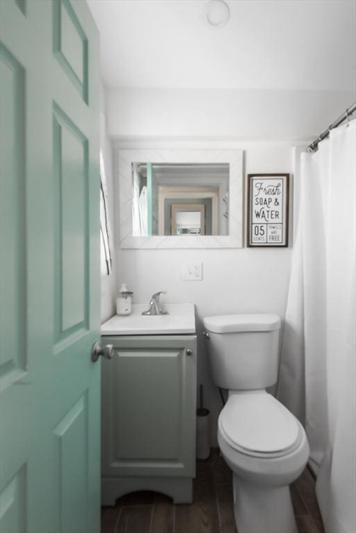 full bathroom featuring toilet, wood finished floors, and vanity