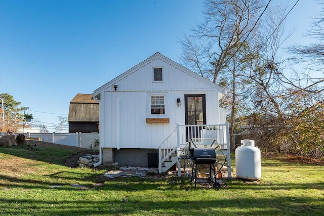 exterior space with roof with shingles, a front yard, and fence