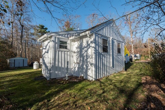 exterior space with an outbuilding, a lawn, and a shed