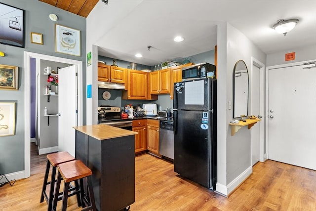 335 Cypress St Unit 2V, Manchester, NH 03103 - kitchen with black appliances, under cabinet range hood, light wood-style floors, a kitchen breakfast bar, and recessed lighting