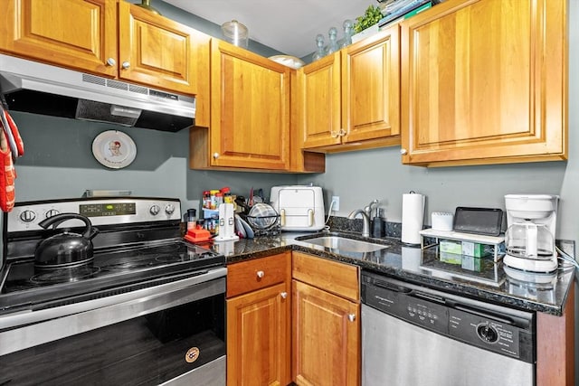 335 Cypress St Unit 2V, Manchester, NH 03103 - kitchen with appliances with stainless steel finishes, under cabinet range hood, dark stone counters, and brown cabinetry