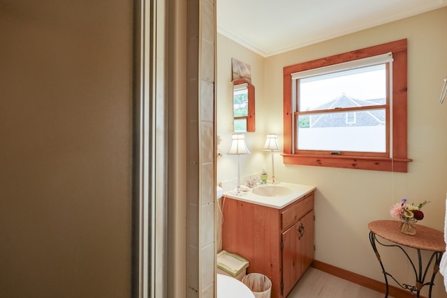 bathroom featuring vanity, ornamental molding, and toilet