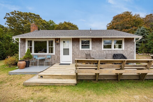 rear view of property with a wooden deck and a yard