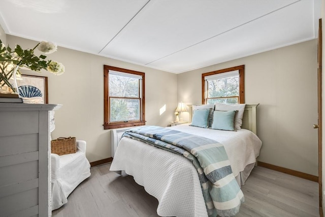 bedroom with multiple windows and light hardwood / wood-style floors