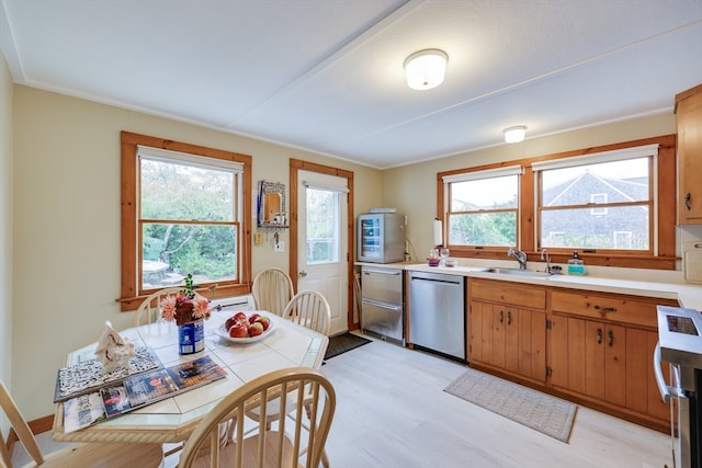 kitchen with range, dishwasher, sink, and light hardwood / wood-style flooring