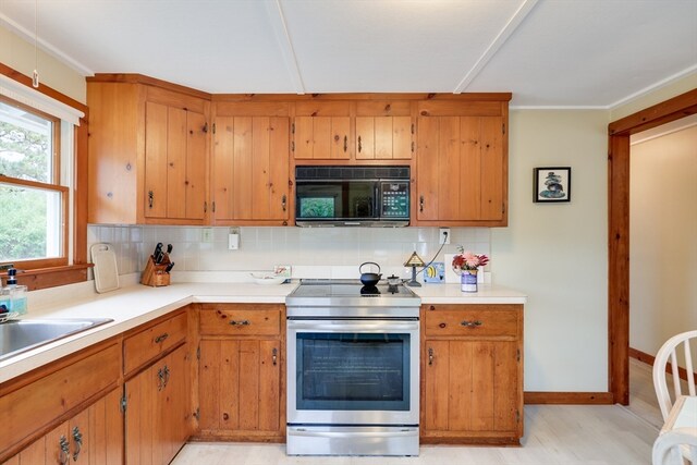 kitchen featuring decorative backsplash, sink, stainless steel range with electric cooktop, and light hardwood / wood-style flooring