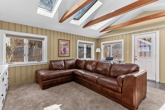 carpeted living room featuring a healthy amount of sunlight and lofted ceiling with skylight