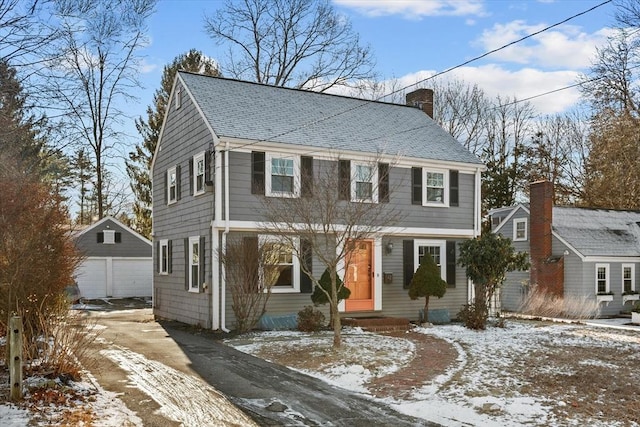 colonial home with a garage and an outdoor structure