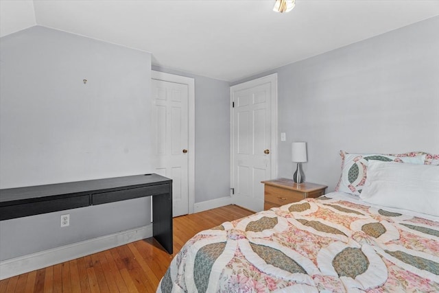 bedroom featuring light wood-type flooring and lofted ceiling