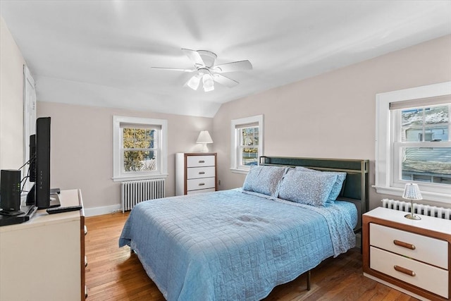 bedroom with ceiling fan, radiator heating unit, and hardwood / wood-style flooring