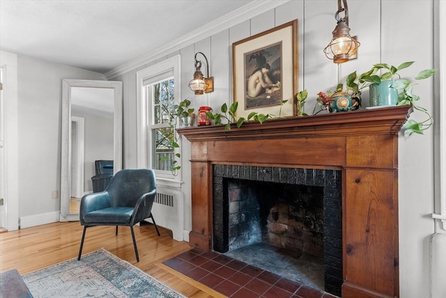 living area with a tiled fireplace, dark wood-type flooring, and ornamental molding