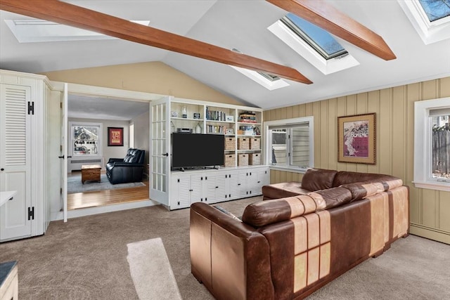 living room featuring vaulted ceiling with skylight, a baseboard heating unit, radiator heating unit, and light carpet