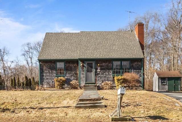 view of front of property featuring a front yard and a storage shed