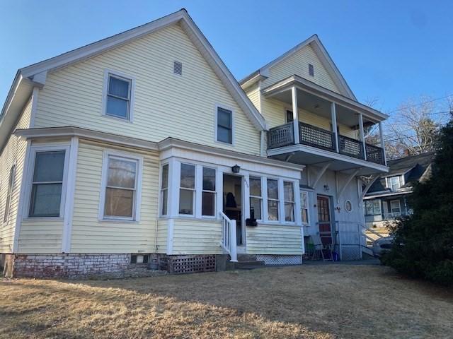 rear view of house featuring entry steps and a balcony