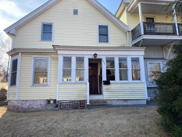 back of property featuring entry steps and a balcony