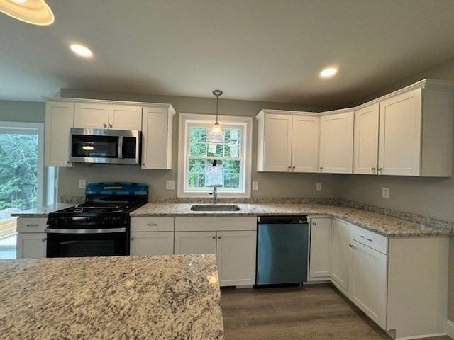 kitchen with stainless steel microwave, white cabinetry, black range with gas cooktop, a sink, and dishwasher