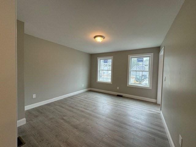 empty room with baseboards and wood finished floors