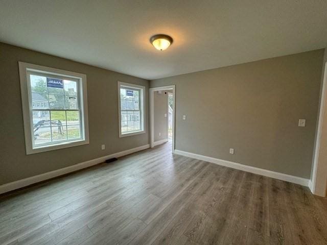 unfurnished room with wood finished floors and baseboards