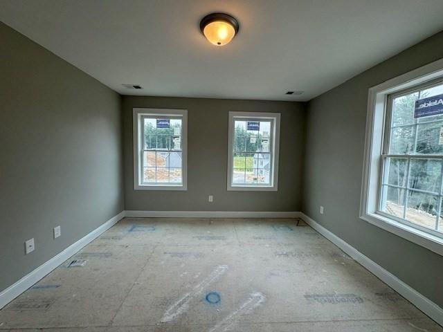 spare room featuring visible vents and baseboards