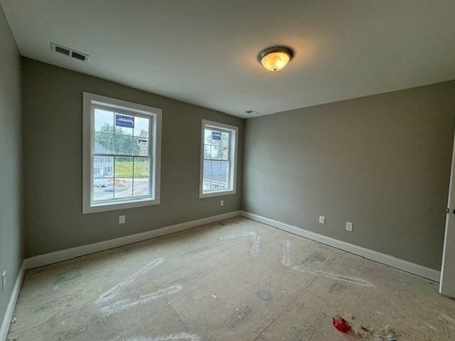 unfurnished room with visible vents and baseboards