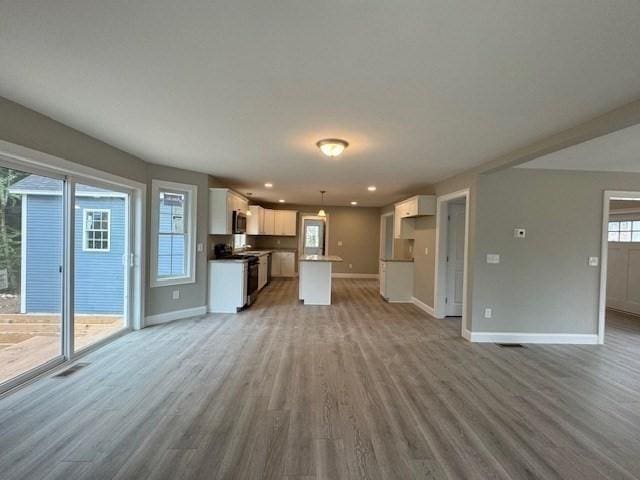 unfurnished living room with baseboards and light wood-style floors