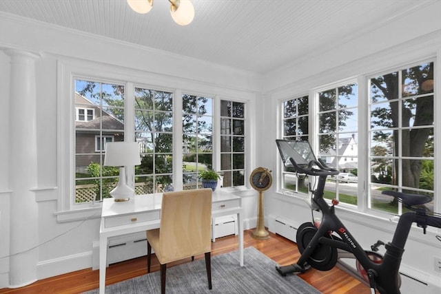 sunroom featuring a baseboard heating unit and a healthy amount of sunlight