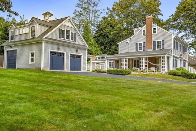 rear view of property with a garage and a lawn