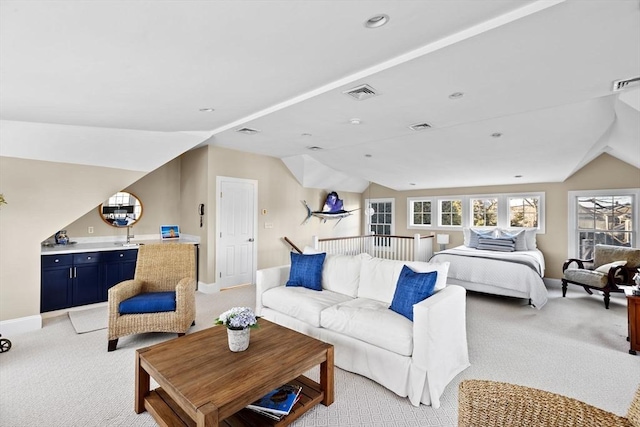 bedroom featuring light carpet, vaulted ceiling, visible vents, and baseboards