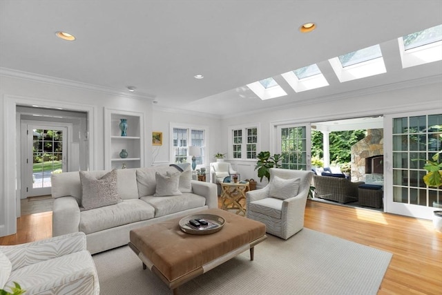 living area featuring light wood-style flooring, recessed lighting, a wealth of natural light, and crown molding