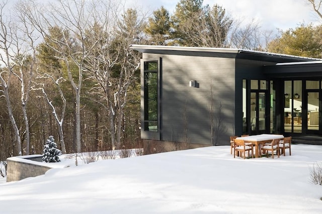 snow covered structure featuring french doors