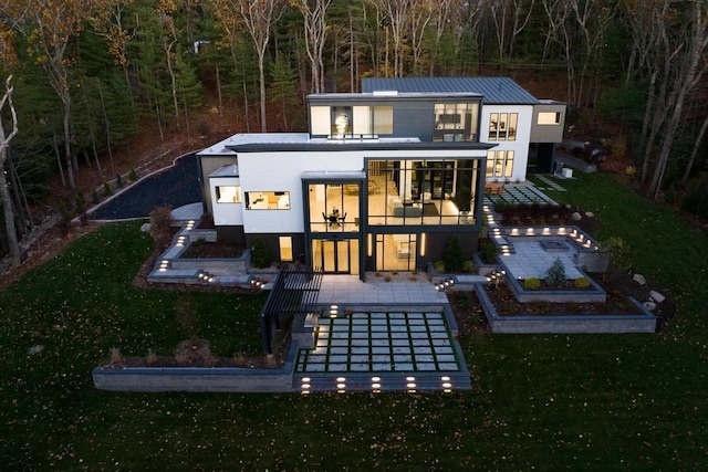 back of property with a yard, a patio area, and a balcony