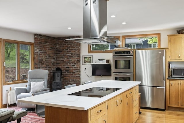 424 Sudbury St, Marlborough, MA 01752 - kitchen featuring stainless steel appliances, island exhaust hood, radiator, a kitchen island, and light wood-style flooring