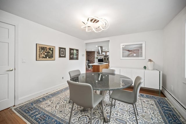 424 Sudbury St, Marlborough, MA 01752 - dining room featuring a baseboard heating unit, wood finished floors, and baseboards