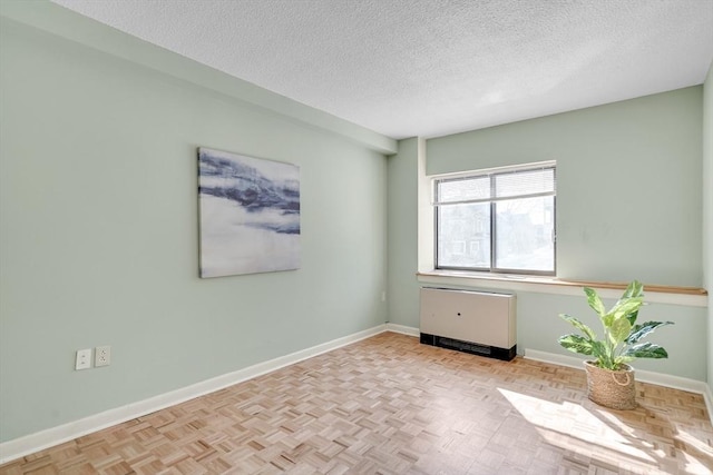 empty room with baseboards and a textured ceiling