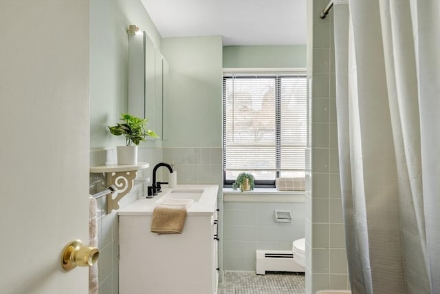 bathroom featuring curtained shower, toilet, vanity, tile walls, and baseboard heating