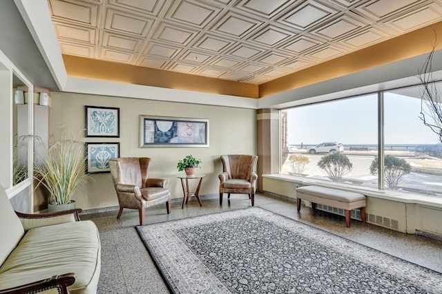 sitting room with an ornate ceiling, baseboards, and speckled floor