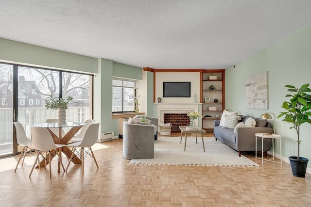 living area featuring a textured ceiling, a fireplace, a baseboard radiator, and baseboards