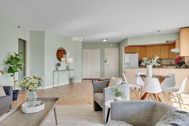 living room featuring a textured ceiling and baseboards