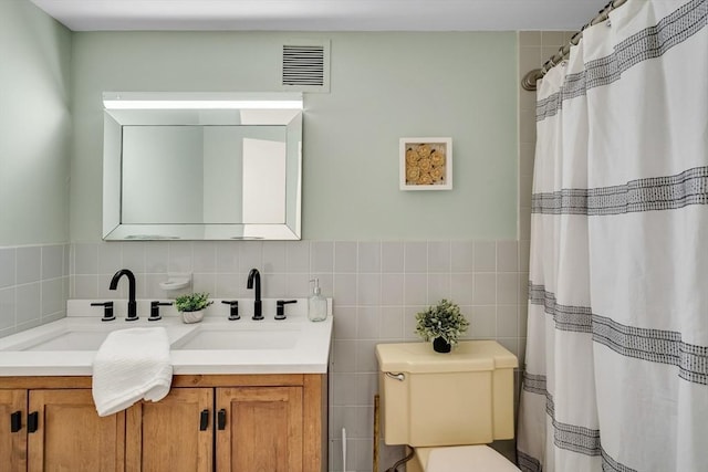 full bath featuring tile walls, visible vents, vanity, and toilet