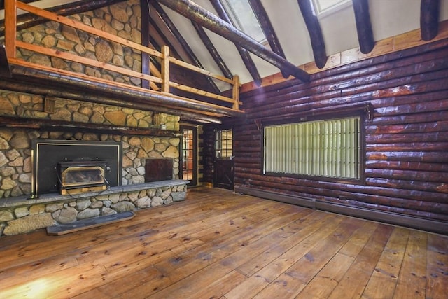 135 Pine St, Rochester, MA 02770 - unfurnished living room with rustic walls, high vaulted ceiling, beam ceiling, wood-type flooring, and a wood stove