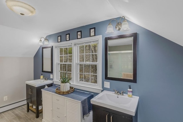 331 Townsend Rd, Groton, MA 01450 - full bath with vaulted ceiling, a baseboard heating unit, wood finished floors, two vanities, and an enclosed shower