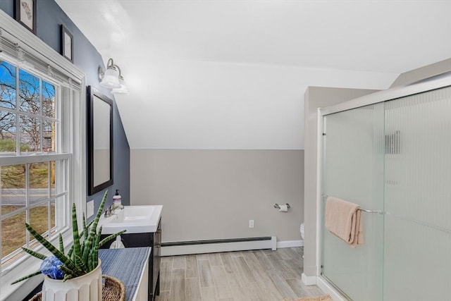 331 Townsend Rd, Groton, MA 01450 - full bathroom featuring a baseboard radiator, double vanity, a stall shower, wood finished floors, and lofted ceiling
