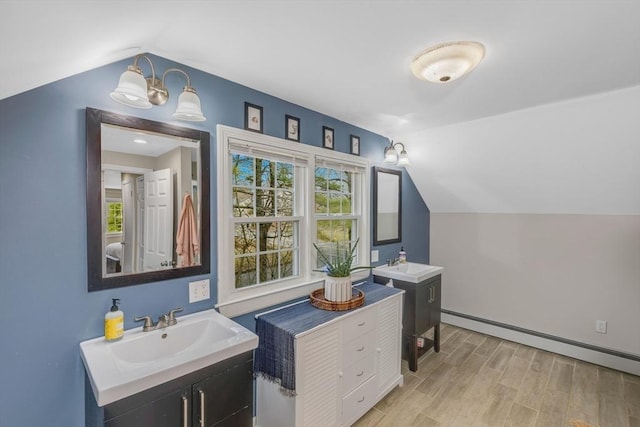 331 Townsend Rd, Groton, MA 01450 - bathroom with lofted ceiling, wood finished floors, baseboard heating, plenty of natural light, and two vanities