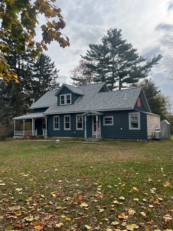 view of front facade featuring a storage shed and a front lawn