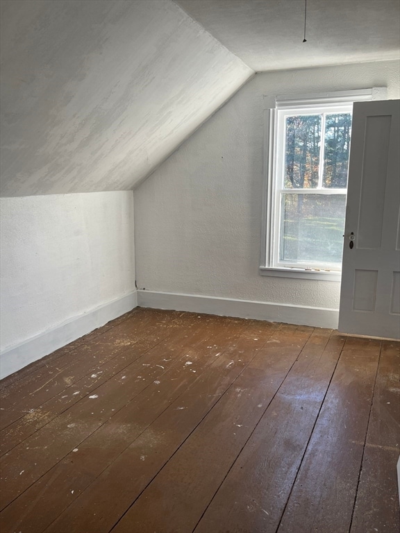 additional living space featuring dark hardwood / wood-style flooring and vaulted ceiling