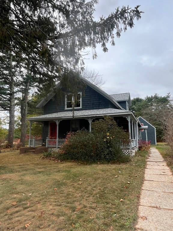 view of side of property featuring a porch and a yard