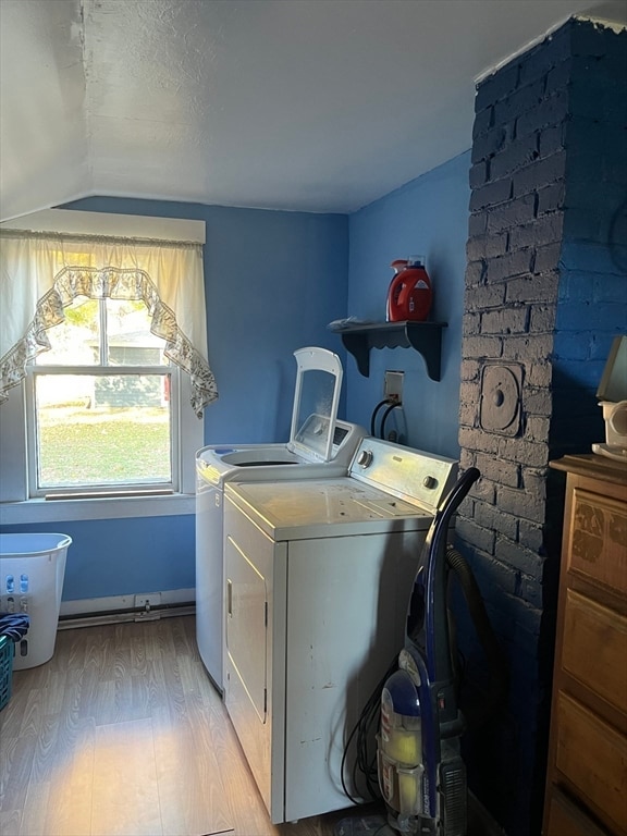 clothes washing area featuring light hardwood / wood-style floors and washer and clothes dryer