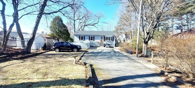 view of front of home with driveway and fence