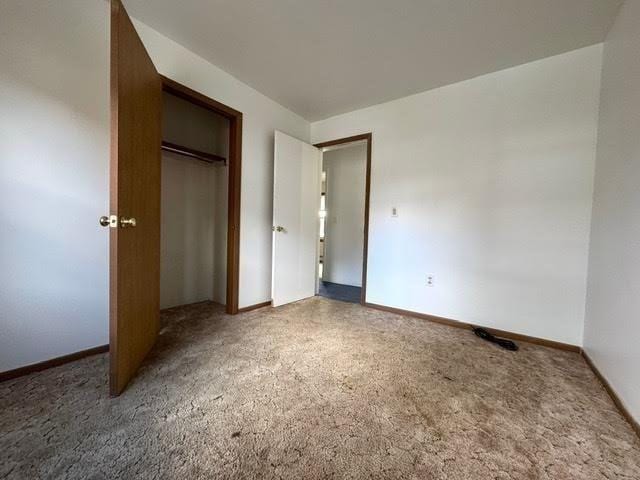 unfurnished bedroom with a closet and baseboards